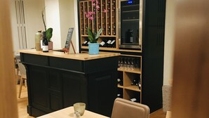 Un restaurante con zona de bar, estantes de madera con botellas y un letrero que dice "Les Tilleuls".
