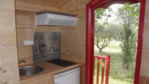 A compact kitchen with a sink, a dishwasher, and a sign indicating a café. - Provence Roulottes Hébergement insolite (Barbentane)