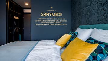 A modern bedroom with a bed, pillows, and a wall with a decorative pattern.