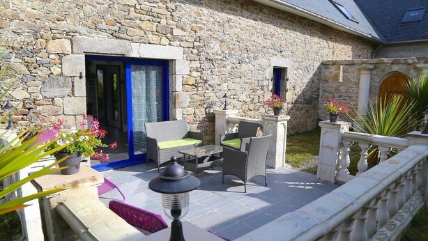 A stone building with a patio area featuring outdoor furniture and a lantern. - Ti Anna Breizh cottage label 4 * (Lannilis)