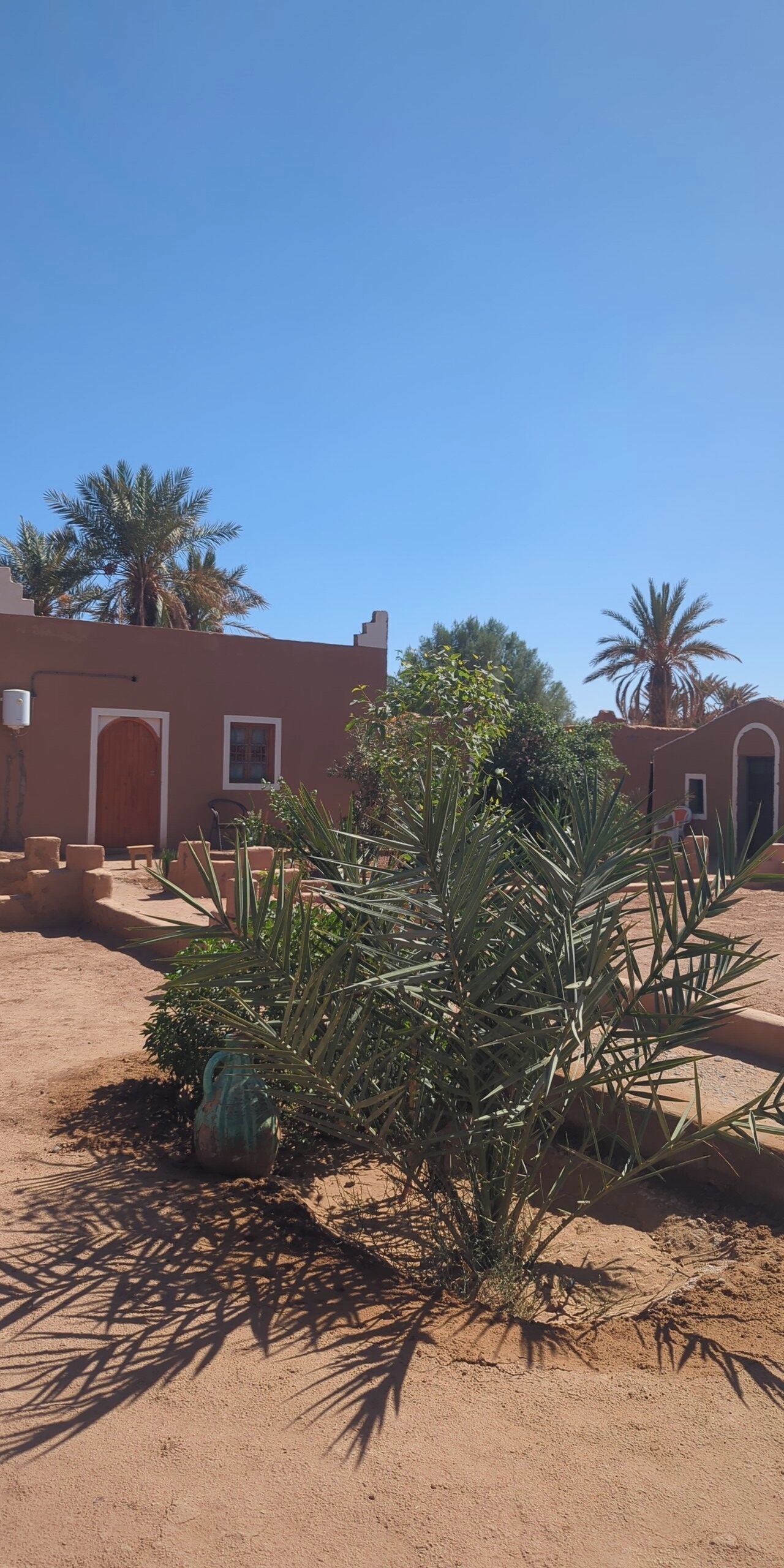 A desert-style building with a flat roof and a large wooden door.