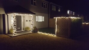 A house with a small covered patio area, a fenced backyard, and a number '60' sign. - B&B By The Sea (Lymington)