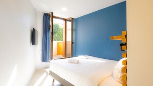 A bedroom with a bed, a TV, and a view of the outdoors. - The People - Marseille - Hostel (Marseille)