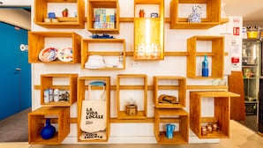 A kitchen with wooden shelves displaying various kitchen items and a blue door. - The People - Marseille - Hostel (Marseille)