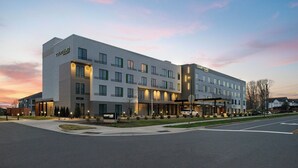 Un hotel Courtyard con diseño moderno, que cuenta con una entrada amplia, múltiples ventanas y una fachada bien iluminada.