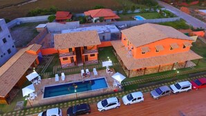 Un complex residencial amb diverses cases, una piscina i una zona d'aparcament.