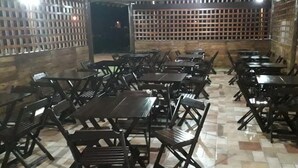 Un restaurant amb diverses taules i caires disposades en files.