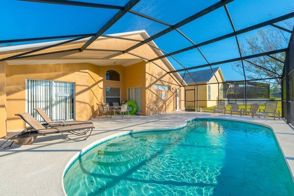 Relax by the pool surrounded by a covered patio and lounge chairs.