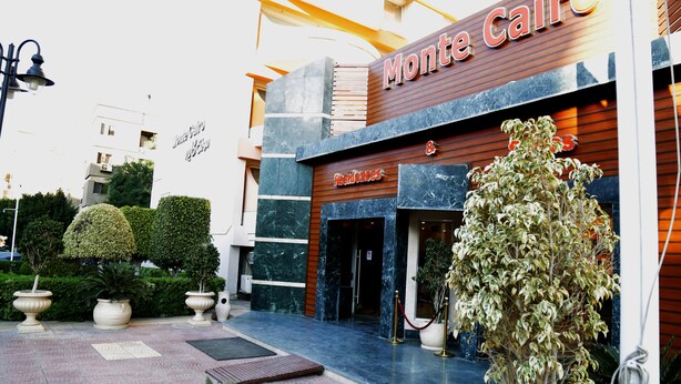 L’entrée d’un hôtel, avec une enseigne indiquant « Monte Cairo » et « Restaurants ».