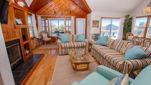 A cozy living room with a wooden ceiling, striped sofas, a glass coffee table, and a fireplace. - Oceanside, Close to beach, Private Pool, Hot Tub, GF1, Ternabout (Duck)