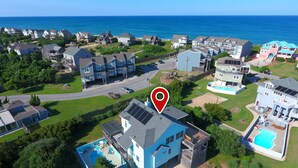 An aerial view of a residential area with houses, a swimming pool, and a large body of water in the background. - Oceanside, Close to beach, Private Pool, Hot Tub, GF1, Ternabout (Duck)