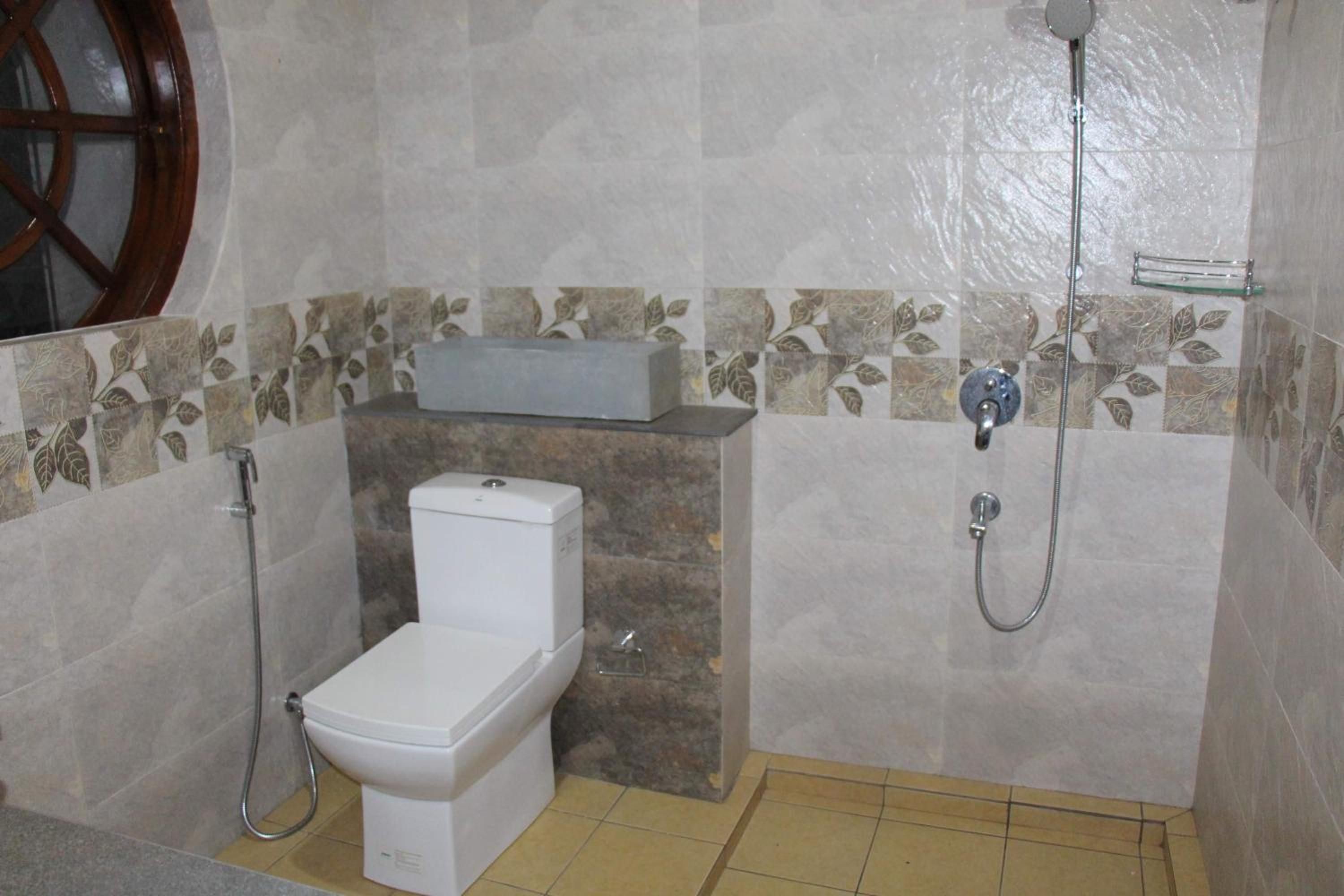 A bathroom with a toilet, a shower, and a sink.
