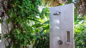 A modern shower enclosure with a rain showerhead, surrounded by lush green foliage. - Rent a Luxury Villa in Bali Close to the Beach, Bali Villa 2035 (Bali)