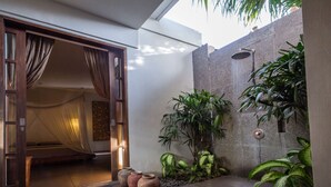 A modern outdoor space with a stone wall, potted plants, and a shower. - Rent a Luxury Villa in Bali Close to the Beach, Bali Villa 2035 (Bali)