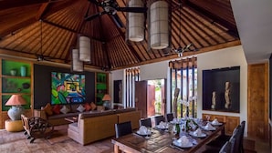A spacious room with a high ceiling, a dining table set for six, and a comfortable seating area with a sofa and chairs. - How to Rent Your Own Private Luxury Holiday Villa in Seminyak for Less than Basic Hotel (Bali)
