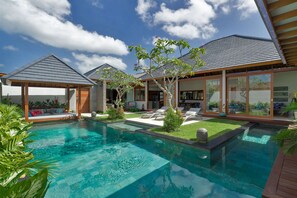 A modern house with a swimming pool, a covered patio, and a well-maintained garden. - Imagine Your Family Renting a Luxury Holiday Villa Close to Seminyak’s Main Attractions (Bali)