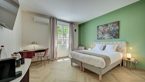 A hotel room with a bed, desk, chair, and a TV. - Logis Hotel Le Blason de Provence (Monteux)