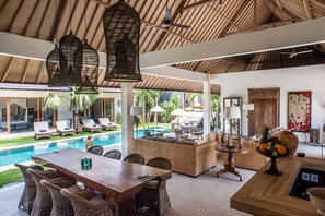 Un vaste espace extérieur doté d’une piscine, de chaises longues et d’une table à manger.