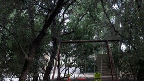 A playground with a slide, swings, and colorful interlocking foam mats. - --- GENEVRIER cottage --- (Quissac)