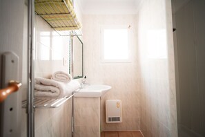 A bathroom with a sink, towel rack, and a window. - --- GENEVRIER cottage --- (Quissac)
