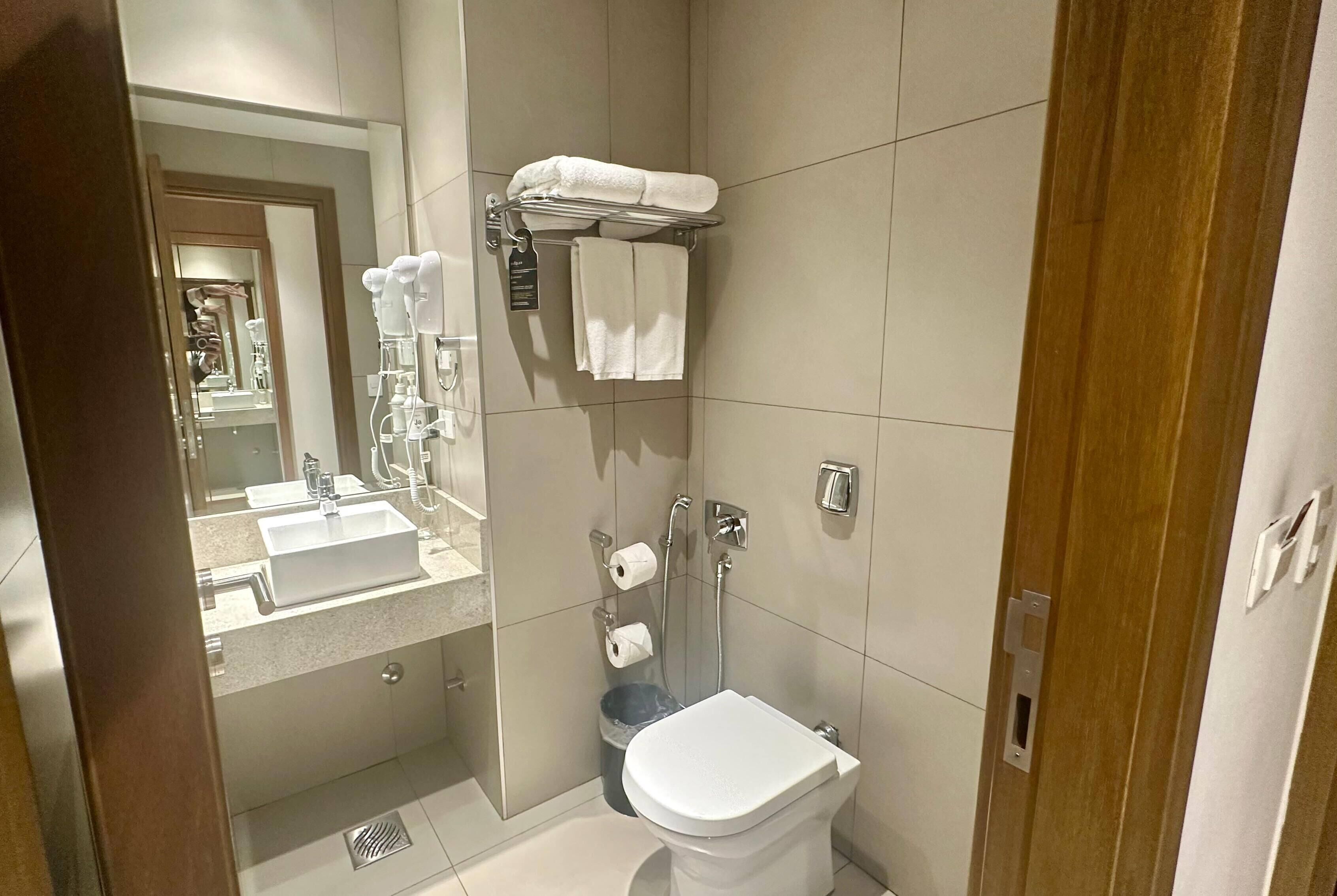 Un bany modern amb un lavabo, vàter i dutxa.