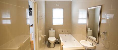 A modern bathroom with a bathtub, toilet, and sink.