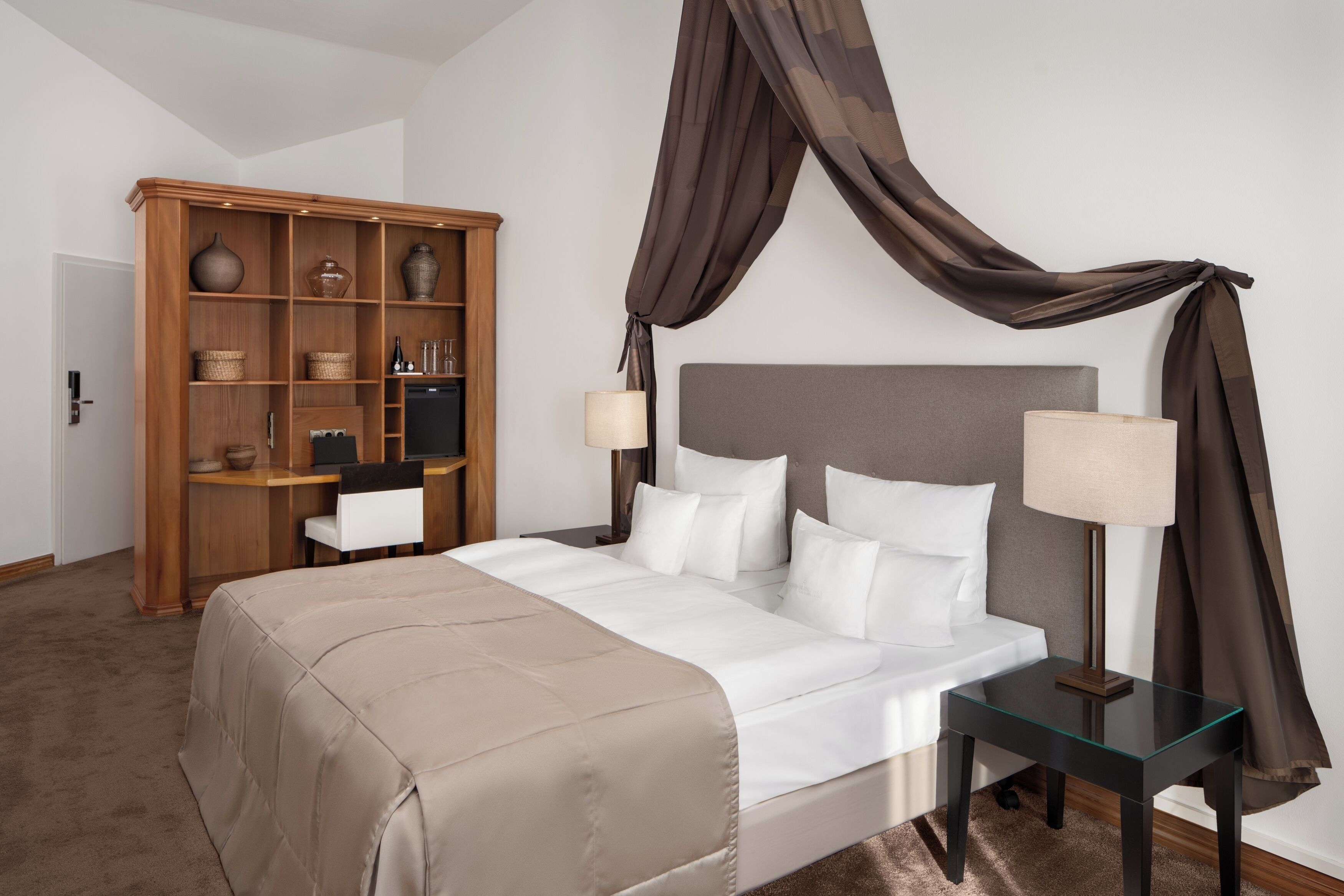 Un dormitorio con cama, mesitas de noche, armario y dosel.