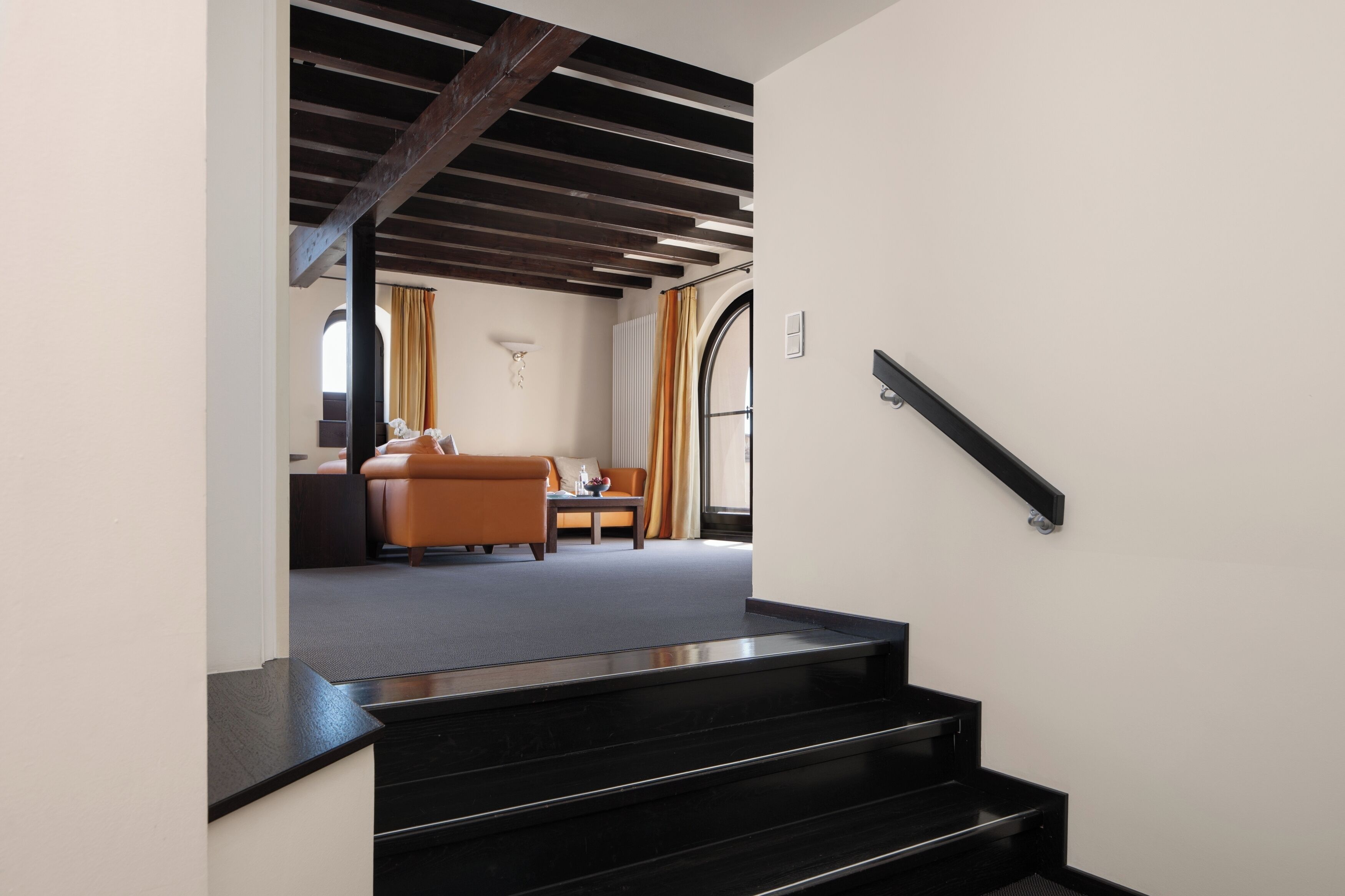 Eine Treppe führt zu einem Wohnbereich mit einem Sofa und einem Couchtisch.