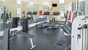 A gym with treadmills, weight machines, and a mirror.