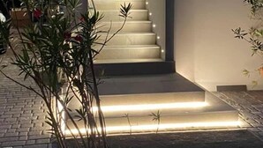 A modern staircase with illuminated steps leading to a door marked "Bertan". - B&B Bertani (Modena)