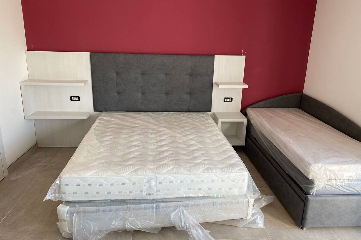Une chambre à coucher avec un lit, une table de chevet et une commode.