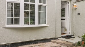 A house with a large bay window, a door with a small window, and a number plate '4' on the wall. - Witts End (Redcar)