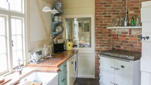 Eine Küche mit Backsteinwand, Holzschränken, Spüle und Herd.