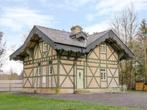Un edificio de estilo Tudor tradicional con un techo pronunciado, estructura de madera vista y un pequeño porche.
