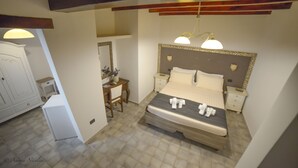 Een slaapkamer met een bed, nachtkastjes, een bureau en een kledingkast.
