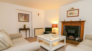 A living room with a fireplace, a sofa, a coffee table, and a lamp. - 11 Tower Street (Richmond)