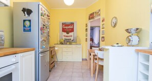 Une cuisine équipée d’un réfrigérateur, d’une cuisinière et de meubles de rangement en bois.