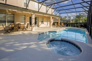 A covered outdoor swimming pool area with lounge chairs and a hot tub. - Minnie & Mickeys Mansion by VillaDirect (Kissimmee)