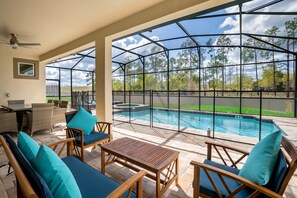 Relax in a comfortable outdoor space with a clear view of the pool, surrounded by a table and chairs.