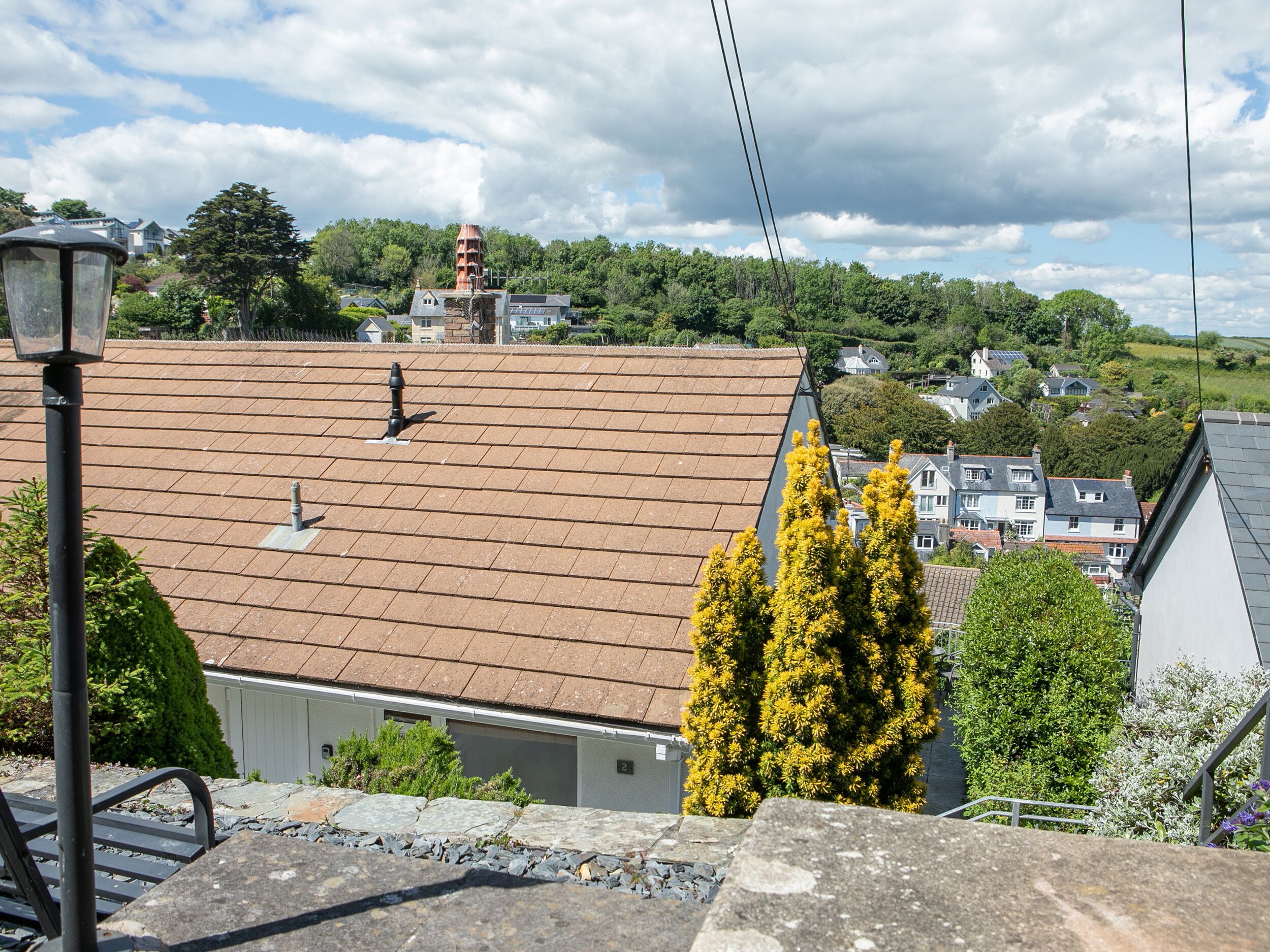 A residential area with a tiled roof, stone steps, and a lamp post.