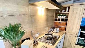 Eine moderne Küche mit Holzarbeitsplatte, Edelstahlgeräten und einem eingebauten Backofen.