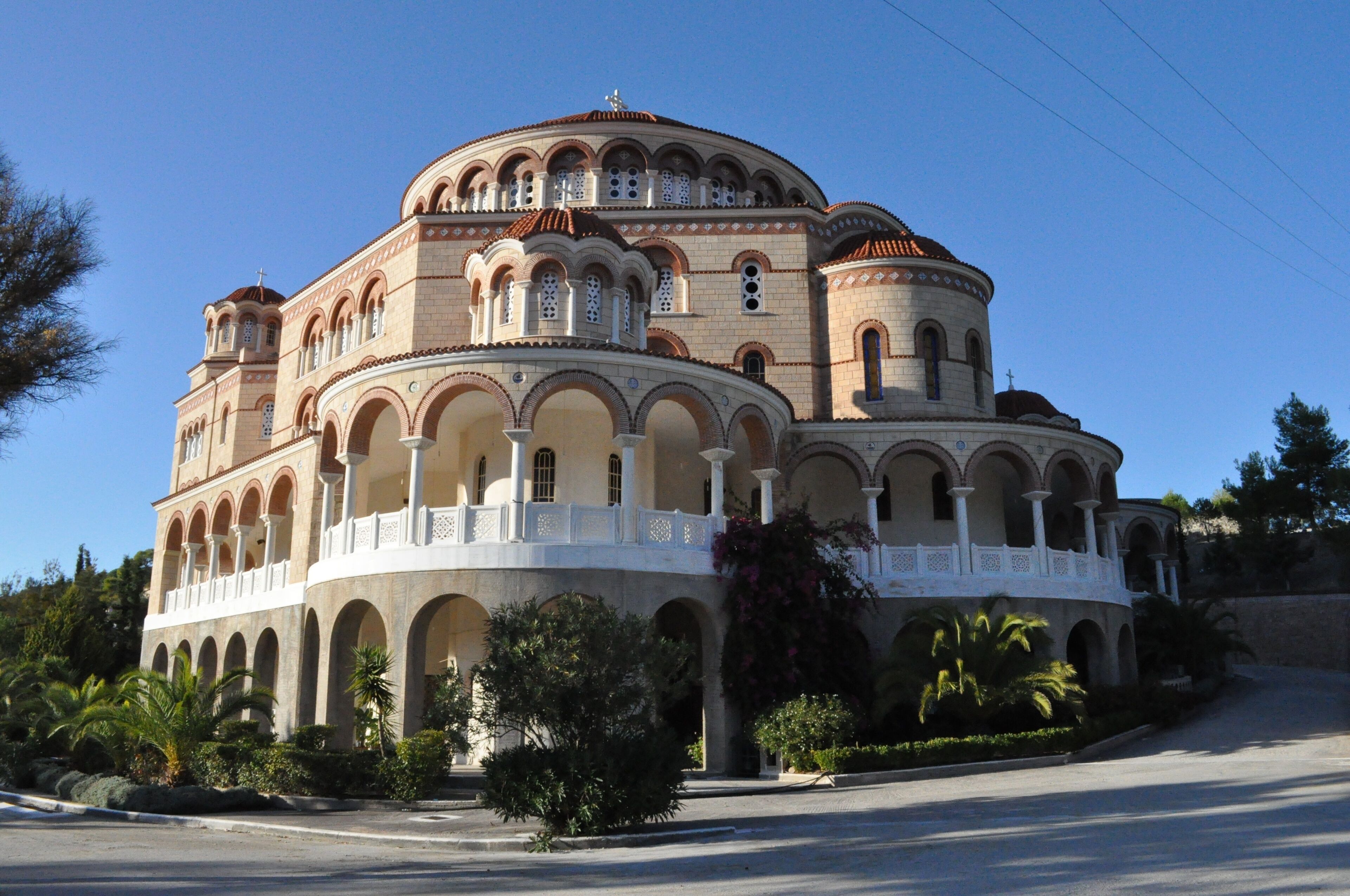 A historic building with multiple arches and domes, surrounded by greenery.