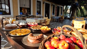 A breakfast buffet with various food items and a fruit basket. - Vagia Beach Apartments (Aegina)