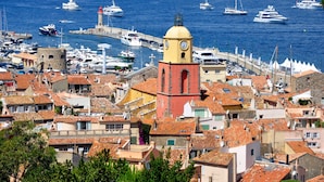 A coastal town with a prominent clock tower, historic buildings, and a marina with various boats. - 1bed Apartment Sleeps 4 - Sea Views, Wifi, Parking (Bormes Les Mimosas)