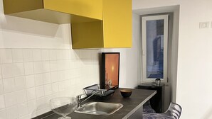 A modern kitchen with a central island, a bar stool, and a window with a view.