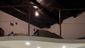 A room with a bunk bed, a sofa, a chair, and a painting on the wall.