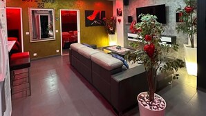 Ein modernes Wohnzimmer mit einer Couch, einem Fernseher und einer Topfpflanze.
