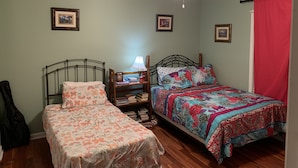 A bedroom with two beds, a ceiling fan, and framed pictures on the walls. - Luxurious Condominium (Dunwoody)