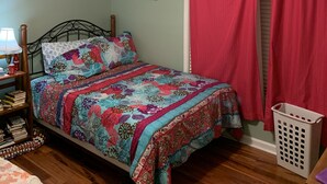 A bedroom with a bed, a ceiling fan, a red curtain, and a laundry basket. - Luxurious Condominium (Dunwoody)