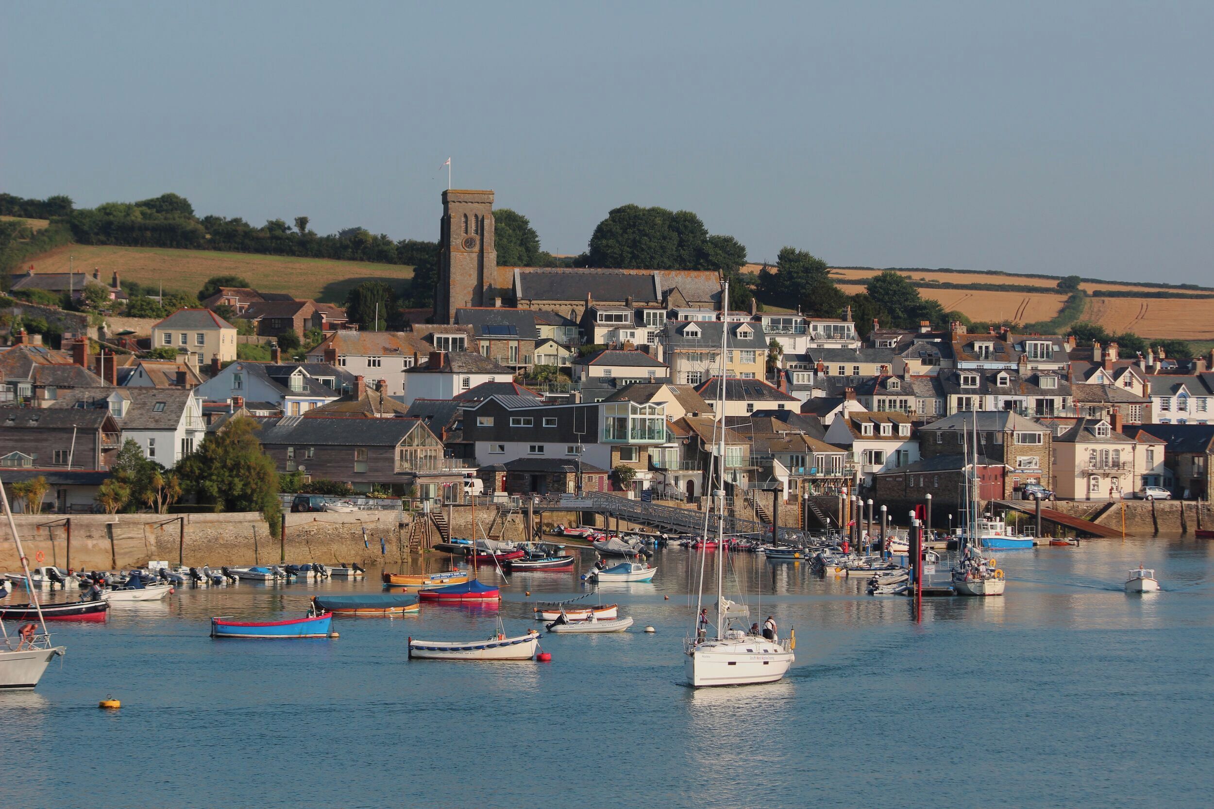 A coastal town with a marina filled with various boats.